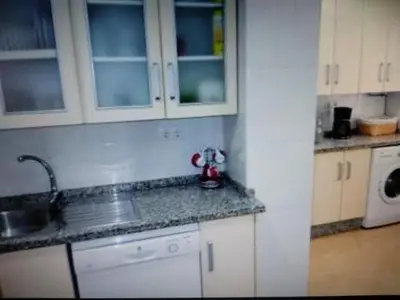 a kitchen with white cabinets and a sink at VIVIENDA TURISTICA MARANt 2 in El Puerto de Santa María