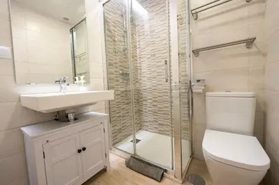 a bathroom with a toilet and a sink and a shower at Alameda apodaca in Cádiz