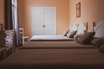 a bedroom with two beds and a door at Sanvi Xerez Centro in Jerez de la Frontera