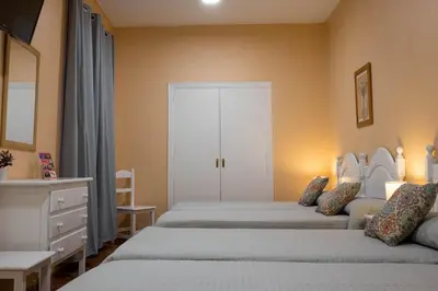 a bedroom with two beds and a dresser at Sanvi Xerez Centro in Jerez de la Frontera