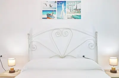 a bedroom with a white bed with two lamps at Bungalow Ramos in Conil de la Frontera