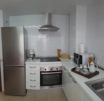 a kitchen with a stainless steel refrigerator and a microwave at Apartamentos Coralba - Dúplex Bahía de Cádiz in San Fernando