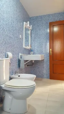 a bathroom with a toilet and a mirror and a sink at Apartamentos Coralba - Dúplex Bahía de Cádiz in San Fernando