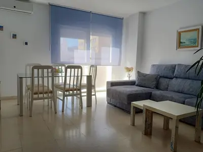 a living room with a couch and a table and chairs at Apartamentos Coralba - Dúplex Bahía de Cádiz in San Fernando