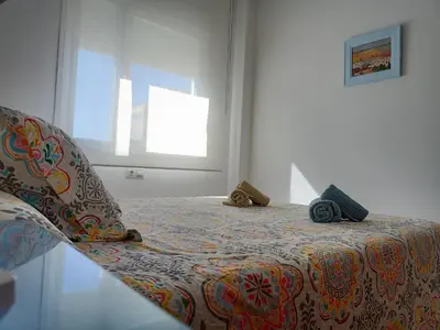 a bedroom with a bed with a suitcase on it at Apartamentos Coralba - Dúplex Bahía de Cádiz in San Fernando