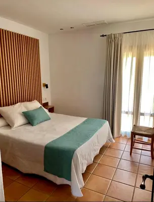 a bedroom with a bed with a green and white blanket at Apartamentos Villafaro Conil in Conil de la Frontera