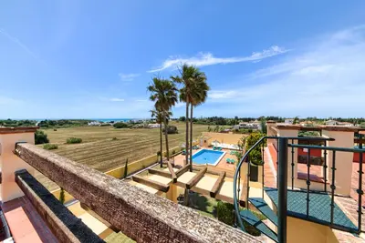 a balcony with a pool and palm trees at Apartamentos Villafaro Conil in Conil de la Frontera