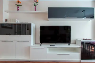 a white entertainment center with a flat screen tv at Apartamento El Pentagrama de Cádiz in Cádiz