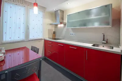 a kitchen with red cabinets and a sink at Apartamento El Pentagrama de Cádiz in Cádiz