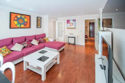 a living room with a purple couch and a table at Apartamento El Pentagrama de Cádiz in Cádiz