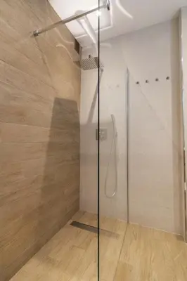 a shower with a glass door in a bathroom at Alquileres Kakiko in Sanlúcar de Barrameda