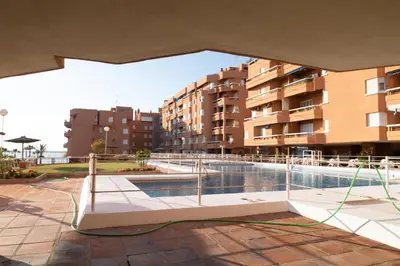 a swimming pool in front of a building at Alquileres Kakiko in Sanlúcar de Barrameda