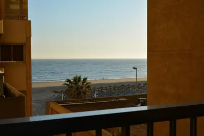 a view of the beach from a balcony at Apartamento Playa Victoria - Cádiz in Cádiz