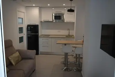 a kitchen with a couch and a table in a room at Apartamento Playa Victoria - Cádiz in Cádiz