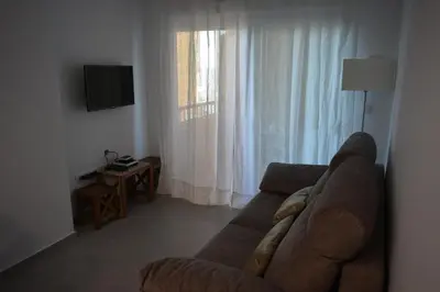 a living room with a couch in front of a window at Apartamento Playa Victoria - Cádiz in Cádiz
