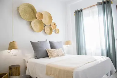 a bedroom with a bed and areath of hats on the wall at Hotel Mariantonia in Chiclana de la Frontera