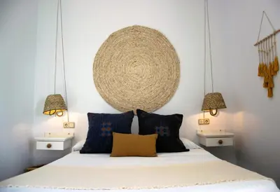 a bedroom with a bed with blue pillows at Hotel Mariantonia in Chiclana de la Frontera