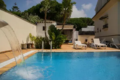 a swimming pool with a fountain in a house at Hotel Mariantonia in Chiclana de la Frontera
