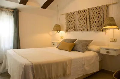a bedroom with a white bed with two pillows at Hotel Mariantonia in Chiclana de la Frontera
