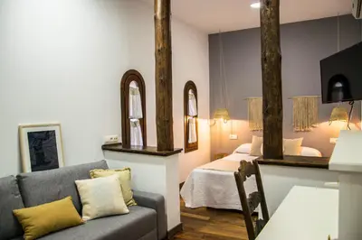 a living room with a couch and a bed at Hotel Mariantonia in Chiclana de la Frontera