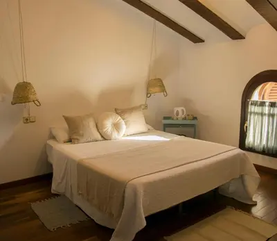 a bedroom with a large bed with two lamps at Hotel Mariantonia in Chiclana de la Frontera