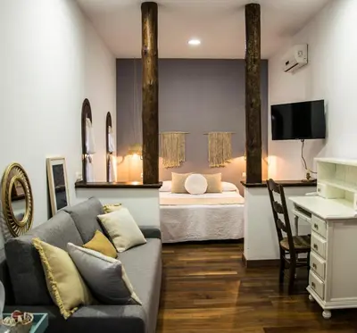 a living room with a couch and a bed at Hotel Mariantonia in Chiclana de la Frontera