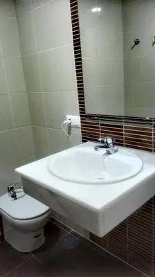 a bathroom with a sink and a toilet and a mirror at Apartamento Santa Faz in El Puerto de Santa María