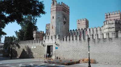 a large castle with a fence in front of it at Apartamento Santa Faz in El Puerto de Santa María