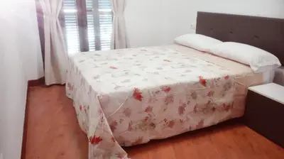 a bedroom with a bed with a white comforter at Apartamento Santa Faz in El Puerto de Santa María