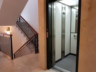 a glass elevator in a hallway with a staircase at Sherryflat Paralejo 10 - Parking in Jerez de la Frontera