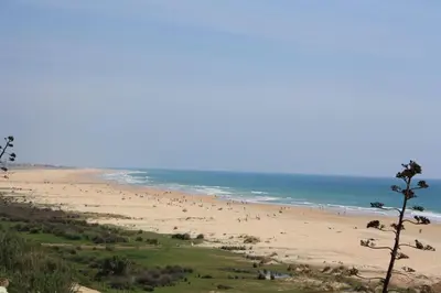 a group of people walking on a beach at Sherryflat Paralejo 10 - Parking in Jerez de la Frontera