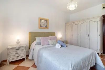 a bedroom with a large bed and a dresser at Grand Beachside Apartment - Cádiz in Cádiz