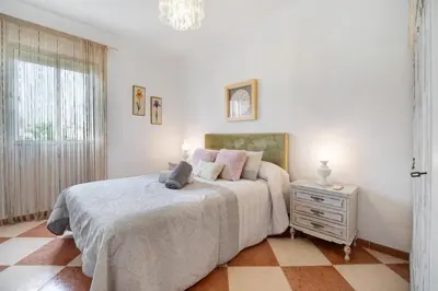 a white bedroom with a bed and a night stand at Grand Beachside Apartment - Cádiz in Cádiz