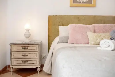 a bedroom with a bed and a nightstand with a lamp at Grand Beachside Apartment - Cádiz in Cádiz