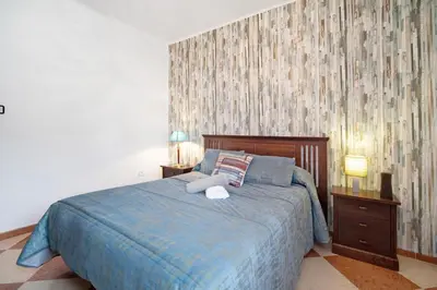 a bedroom with a bed with a blue blanket at Grand Beachside Apartment - Cádiz in Cádiz