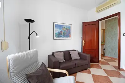 a living room with a couch and a chair at Grand Beachside Apartment - Cádiz in Cádiz