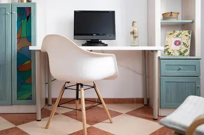 a white chair sitting at a desk with a tv at Grand Beachside Apartment - Cádiz in Cádiz
