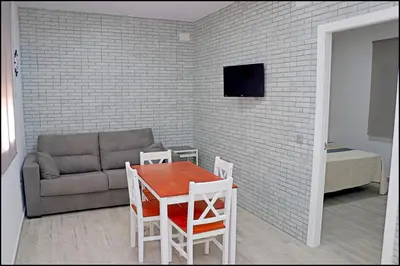 a living room with a couch and a table at Bungalow La Roa V in Conil de la Frontera