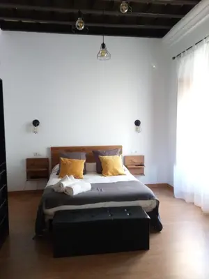 a bedroom with a large bed with yellow pillows at Hospederia 1881 in Chiclana de la Frontera