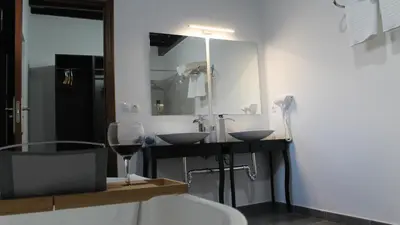 a bathroom with two sinks and a glass of wine at Hospederia 1881 in Chiclana de la Frontera
