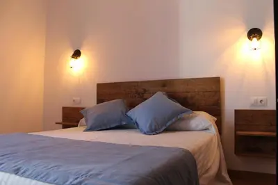a bedroom with a bed with two blue pillows at Hospederia 1881 in Chiclana de la Frontera