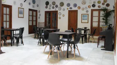 a room with tables and chairs and plates on the wall at Hospederia 1881 in Chiclana de la Frontera