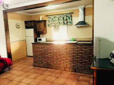 a kitchen with a brick wall and a microwave at Villa Gallardo - Cerca Playa y Pueblo in Conil de la Frontera