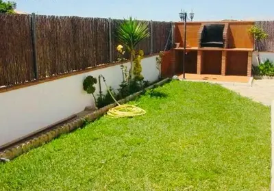 a backyard with a hose in the grass at Villa Gallardo - Cerca Playa y Pueblo in Conil de la Frontera