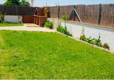 a yard with green grass and a fence at Villa Gallardo - Cerca Playa y Pueblo in Conil de la Frontera