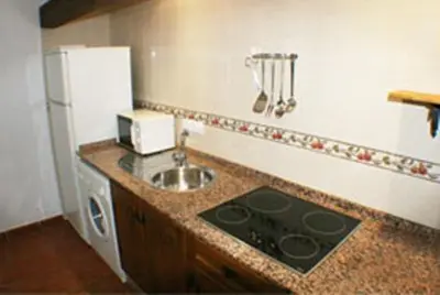 a kitchen with a sink and a refrigerator at Apartamentos La Palmera in Conil de la Frontera