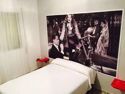 a bedroom with a poster of a group of people at Hotel Sur Utopia in El Puerto de Santa María