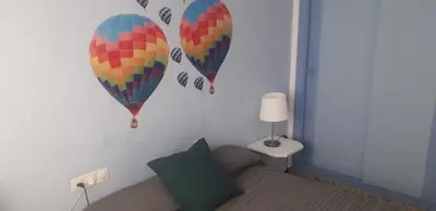 a bedroom with two hot air balloons on the wall at Hotel Sur Utopia in El Puerto de Santa María