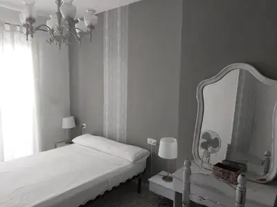 a bedroom with a bed and a large mirror at Hotel Sur Utopia in El Puerto de Santa María