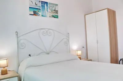 a bedroom with a white bed and two lamps at Bungalow Ramos II in Conil de la Frontera